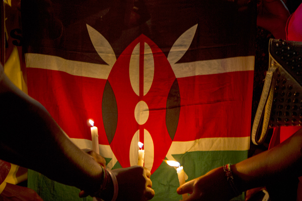Makerere University students hold candles in front of a Kenyan flag on April 8, 2015 in commemoration of the 148 lives lost during a recent attack by the Al-Shabab insurgents in Garissa, Kenya. The Islamist terrorist group killed mostly students in the recent attacks in one of the biggest attacks in Kenya since 1998. PHOTO BY ISAAC KASAMANI