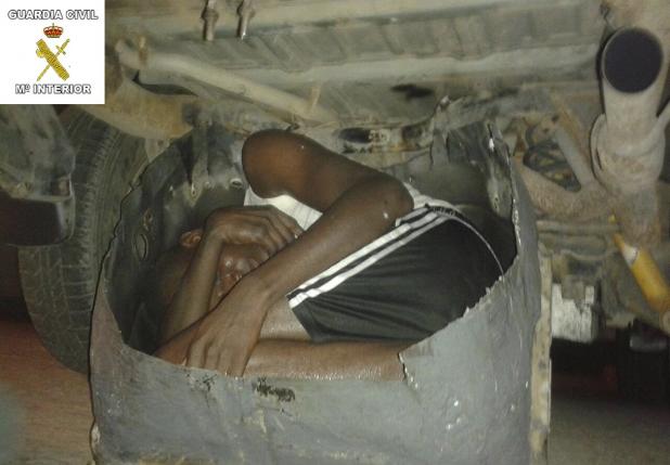 A young African man, who squeezed into tiny hidden compartment in a car to try to enter Spanish North African city of Melilla, is seen in this handout picture released by Spain's Interior Ministry August 14, 2015.